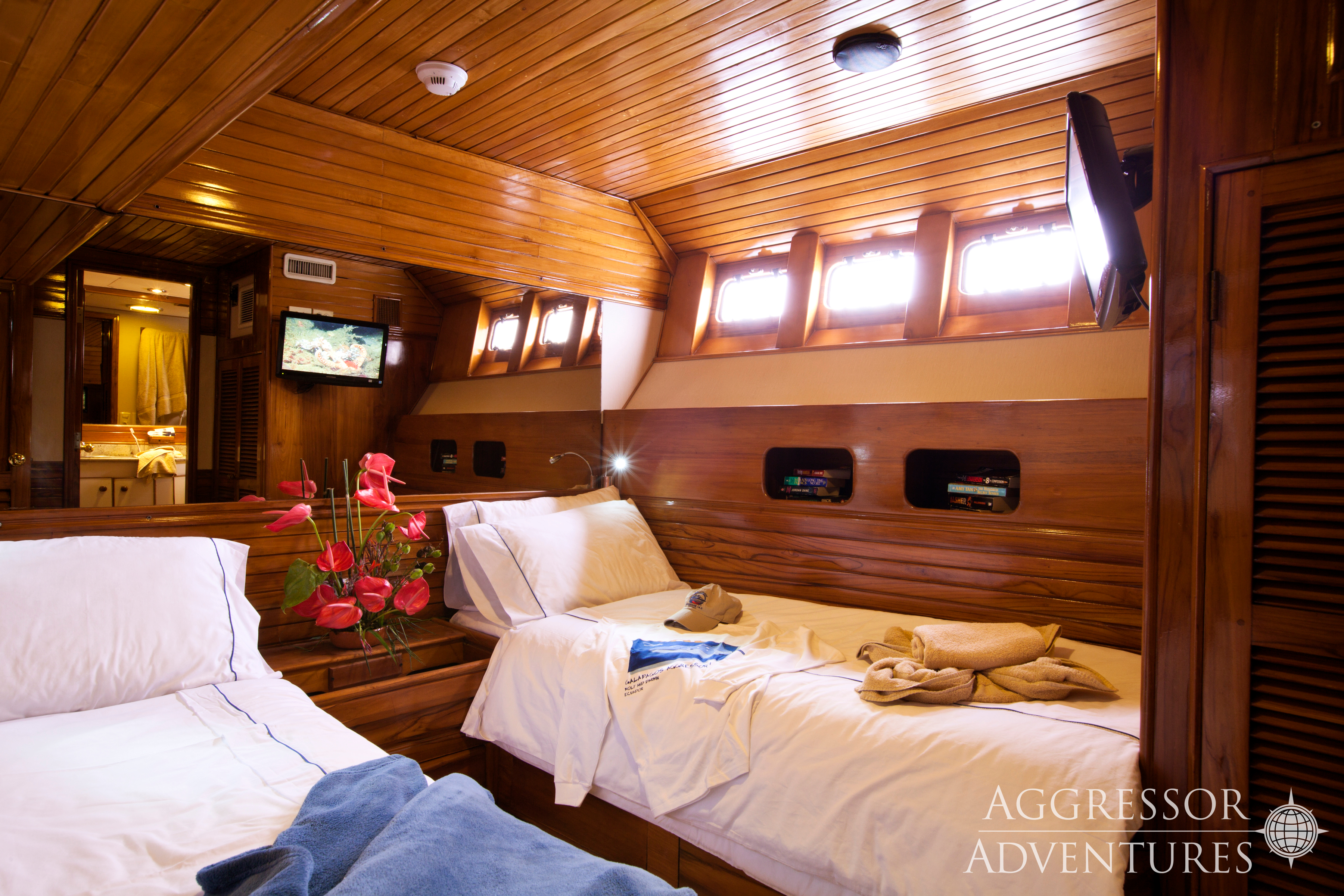 Comfortable twin stateroom with two single beds and porthole windows on Galapagos Aggressor III