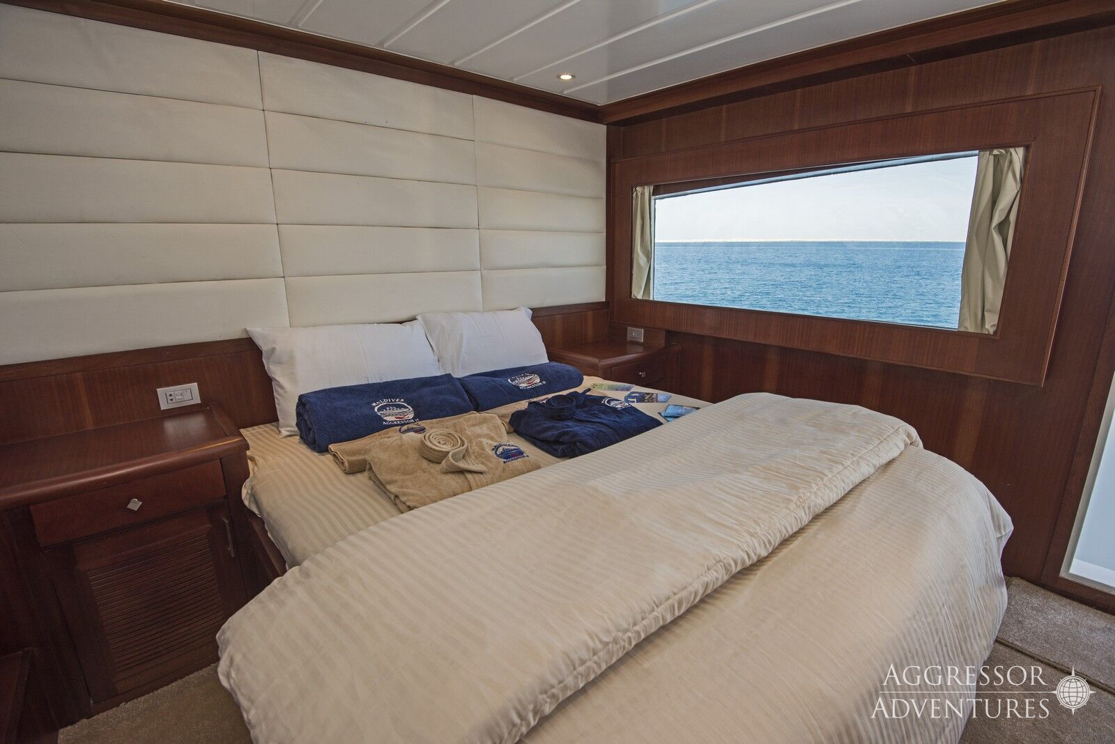 Spacious deluxe stateroom with convertible king or queen bed and picture window on Maldives Aggressor II