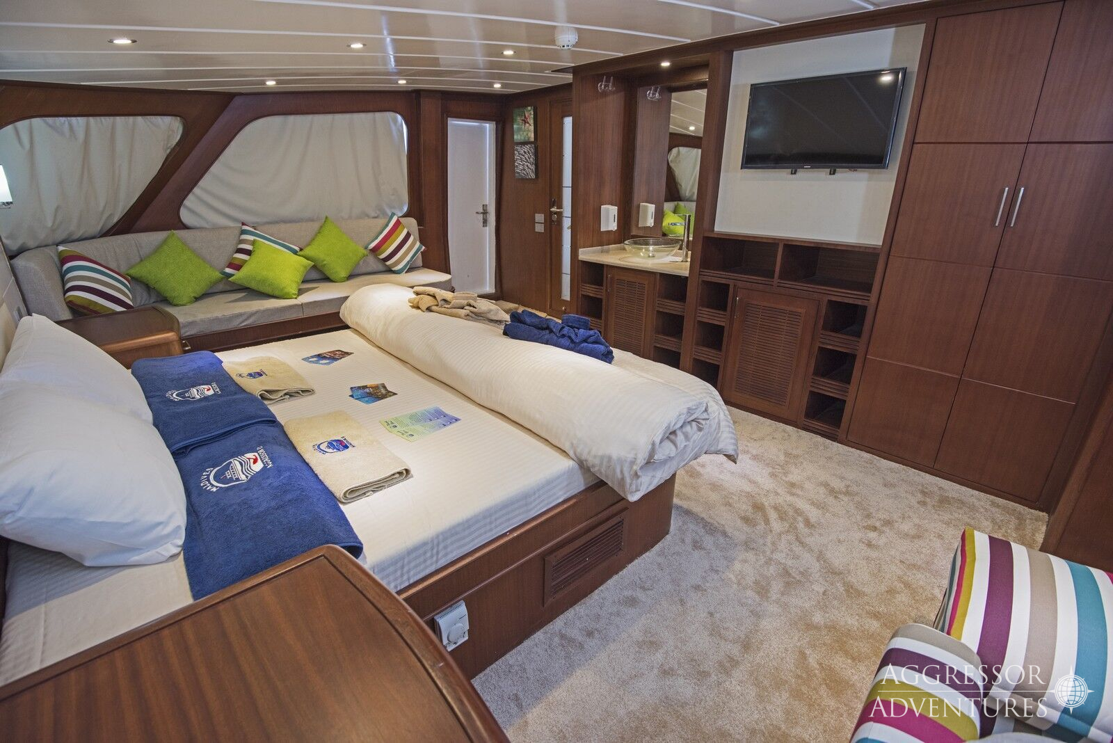 Luxury suite stateroom with queen bed and panoramic windows aboard Maldives Aggressor II