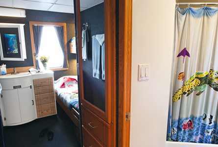 Comfortable deluxe stateroom with Queen size bed and large window on Palau Aggressor II