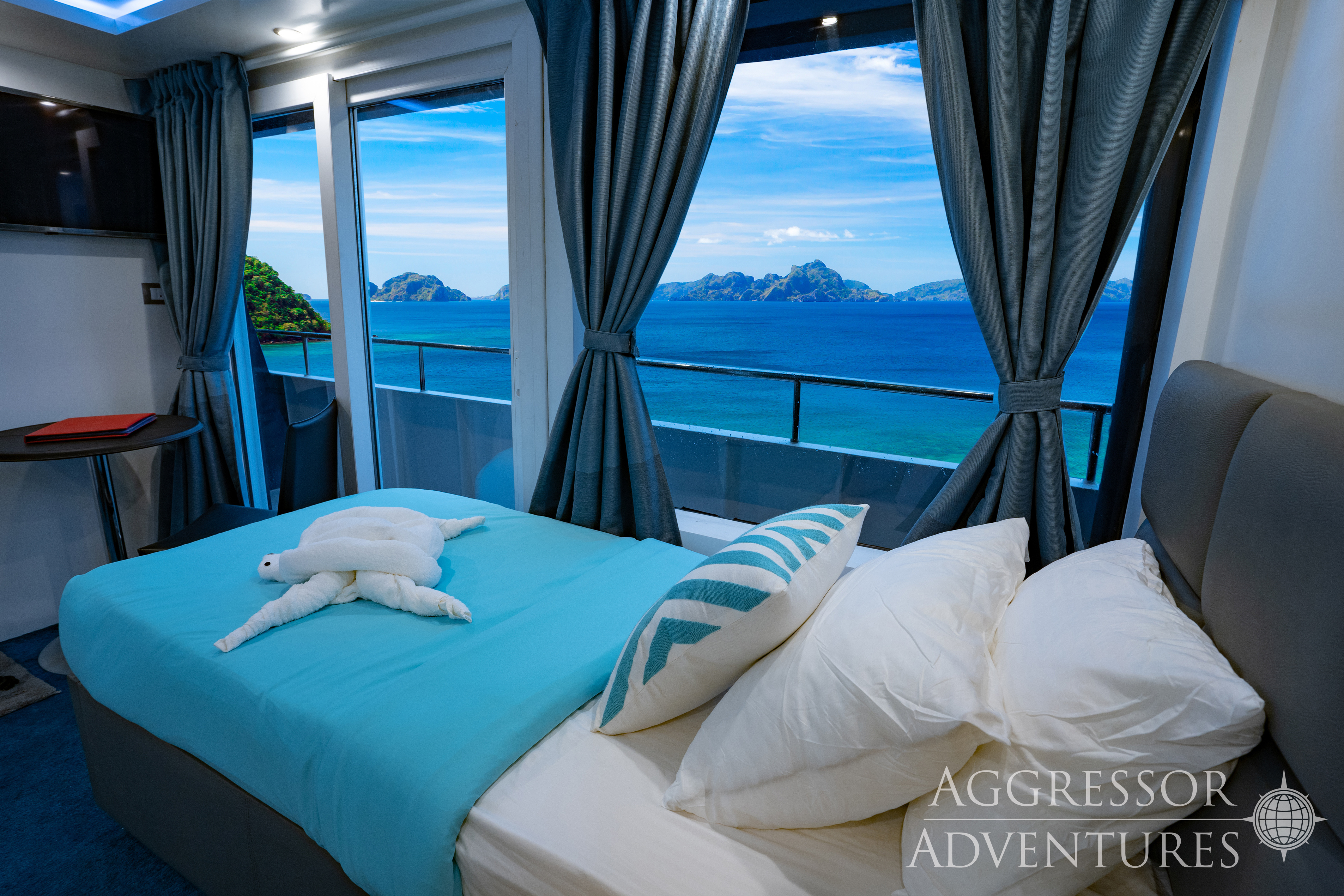 Balcony Stateroom with King bed and panoramic windows aboard Philippines Aggressor