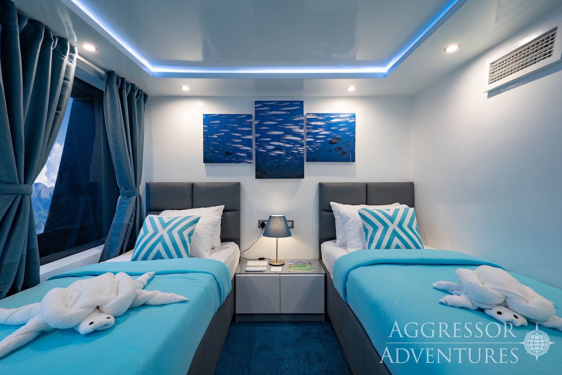 Comfortable main deck twin stateroom with two single beds and panoramic window on Philippines Aggressor