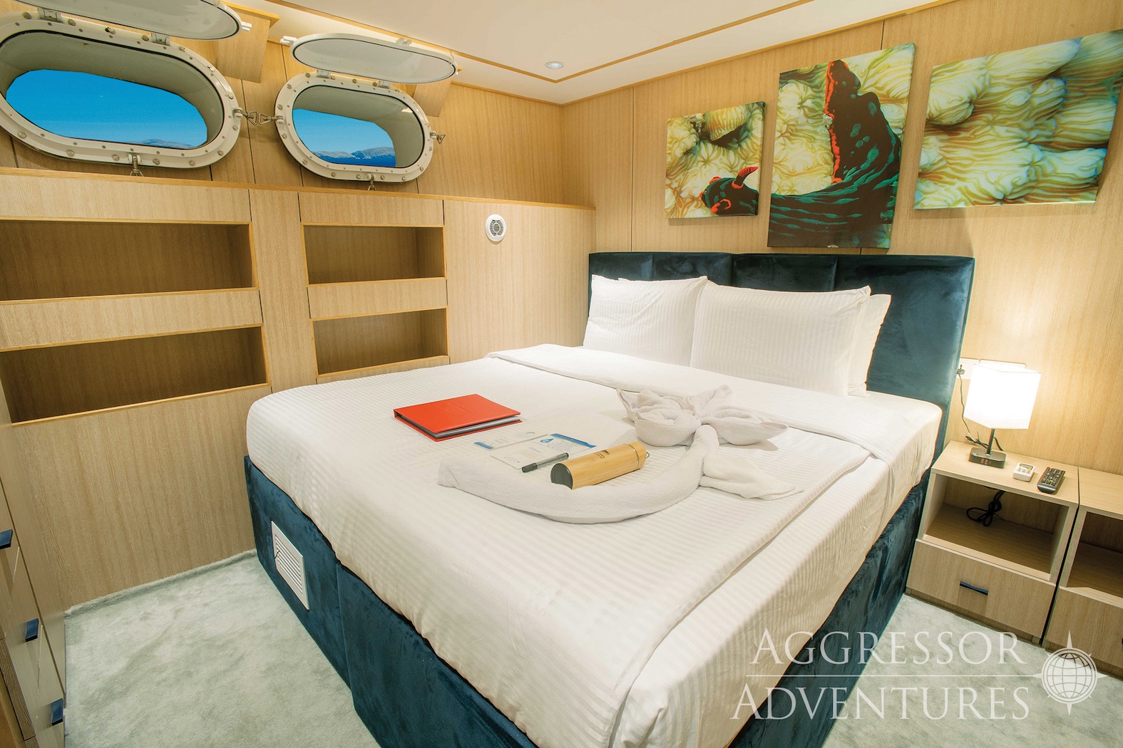 lower deck twin stateroom with double bed, single  and circular window on Philippines Aggressor II