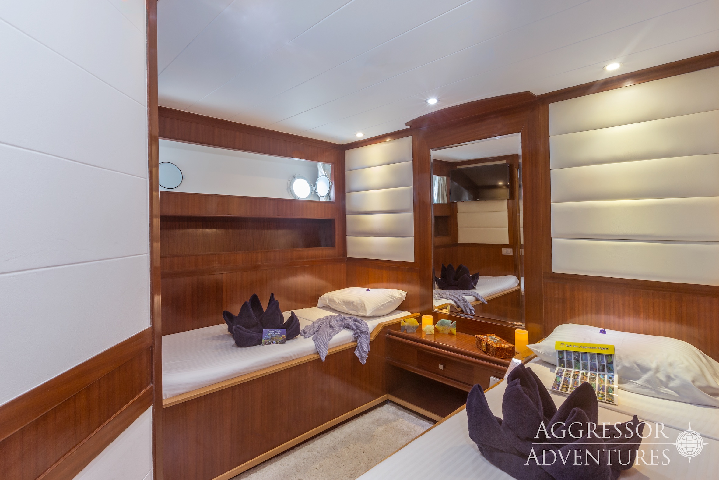 Comfortable twin stateroom with two single beds and porthole windows on Red Sea Aggressor II